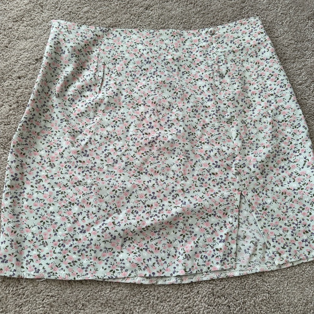 Mini skirt multicolored with flowers. Small buttons on the side
